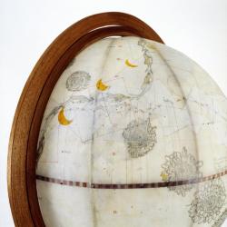 Globe detail, The dolphin presenting the water line of the vessel, intersecting the movement of the sun, in turn fading into the cycles of the moon.